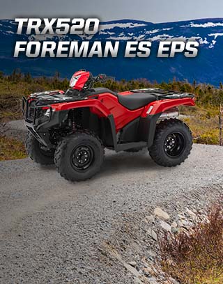 TRX500 Foreman ES EPS. The limitless legend. Image of orange ATV dramatically parked on gravel trail with majestic mountain peaks in background. 