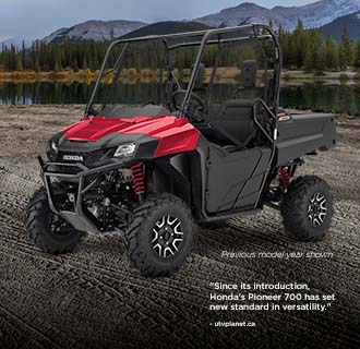 "Since its introduction, Honda's Pioneer 700 has set new standards in versatility." - quote by utvplanet.ca. Image of Pioneer 700 on a grassy plain with a forest in the background.