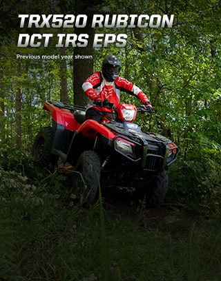 TRX500 Rubicon DCT IRS EPS. Ready for the challenge. Image of ATV rider powerfully steering up rugged dirt trail in the forest